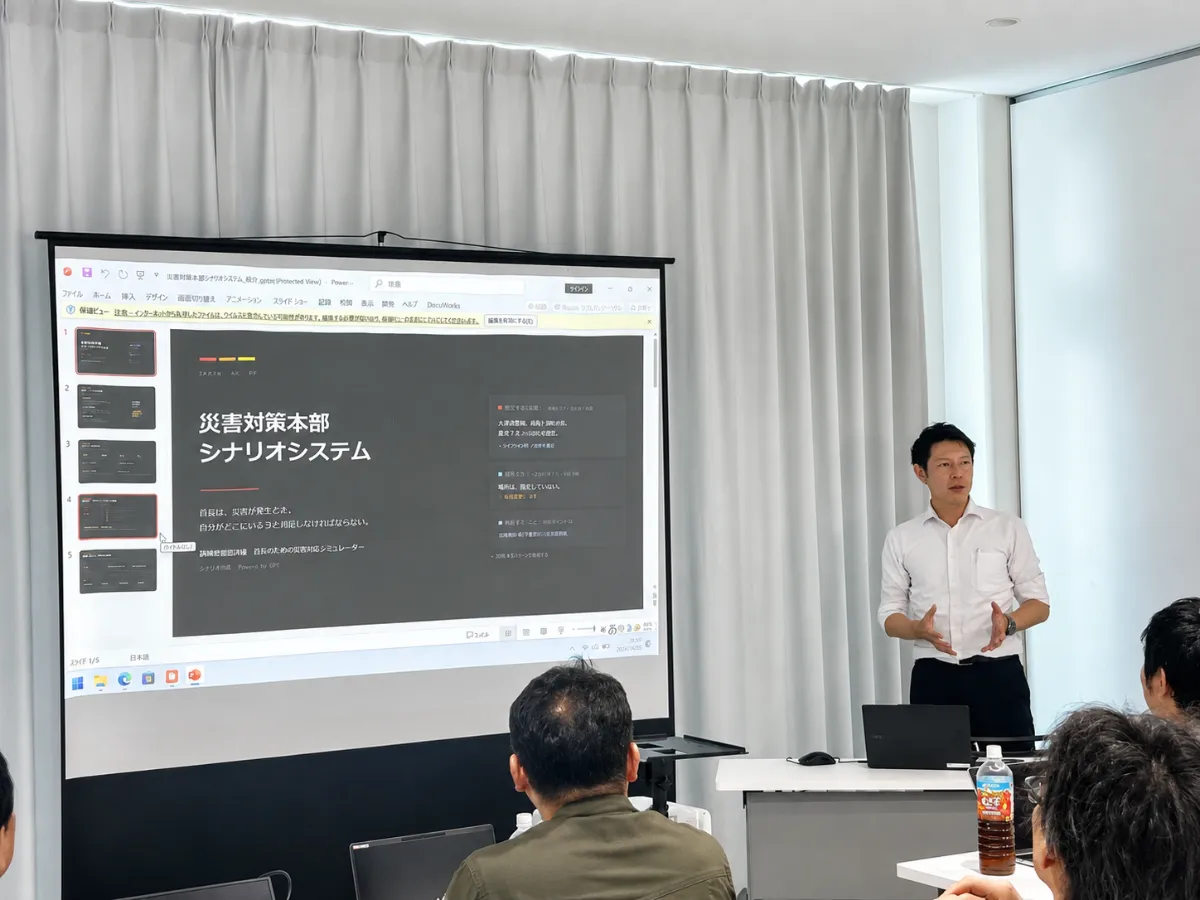 草地博昭市長が席についてノートパソコンを操作している様子